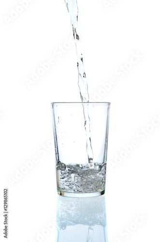 Fresh water pouring in a glass on white background