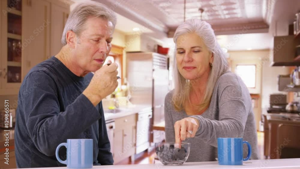 Couple of senior caucasian people sharing bowl of fruit Couple of senior caucasian people sharing bowl of fruit
