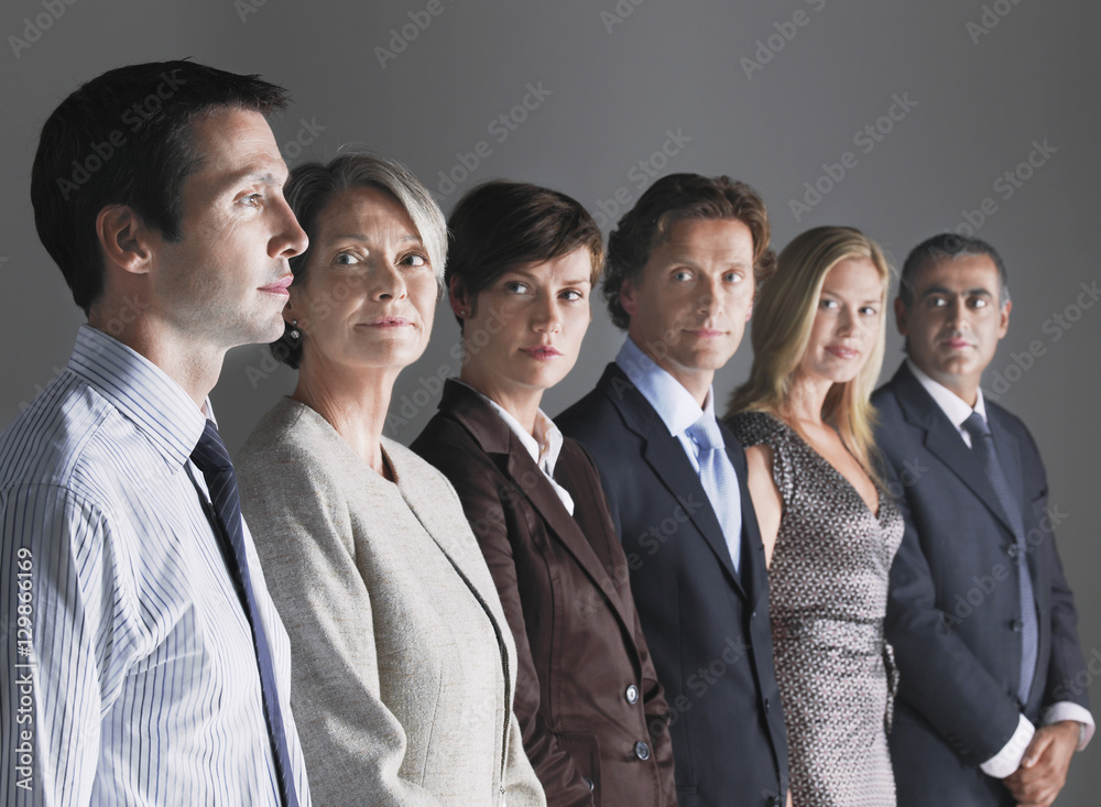 Group of businesspeople in a row looking at businessman Group of businesspeople in a row looking at businessman