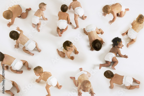 Group of multiethnic babies crawling isolated on white background