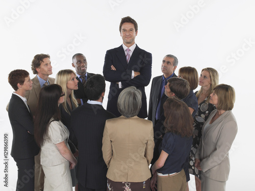 Schilderij op canvas Multiethnic executives around taller businessman against white background