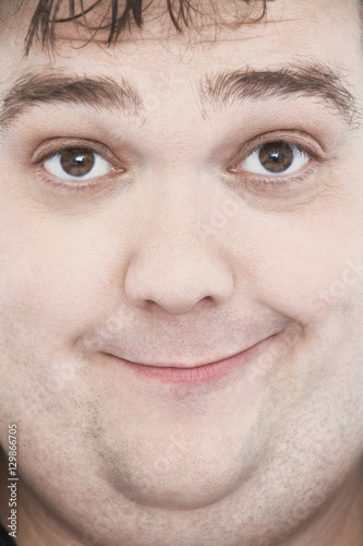 Extreme closeup portrait of an overweight man's face with funny expression