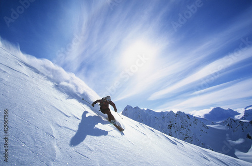 Full length of skier skiing on fresh powder snow photo