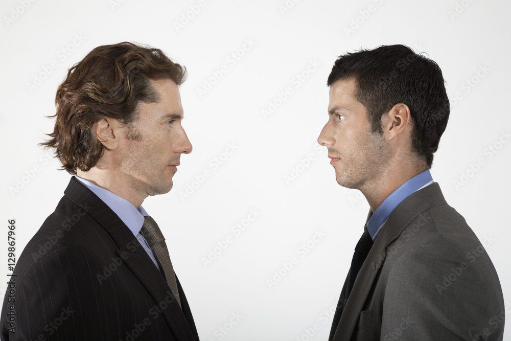 Side view of two businessmen face to face on white background Side view of two businessmen face to face on white background