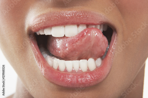 Closeup of woman licking her teeth