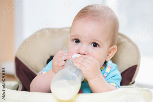 mother feeds her nine-month baby milk house