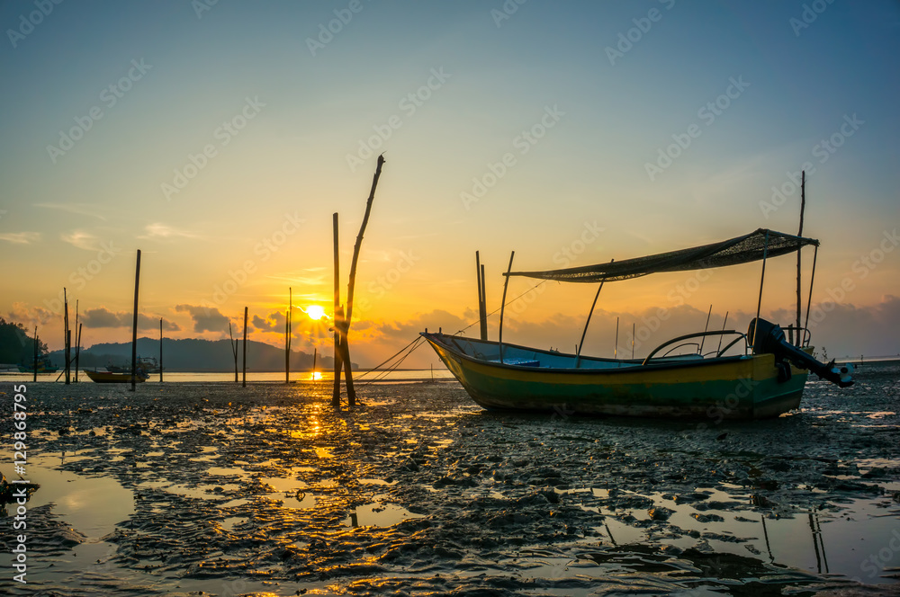 Fishing boat on the beach when sun rising up