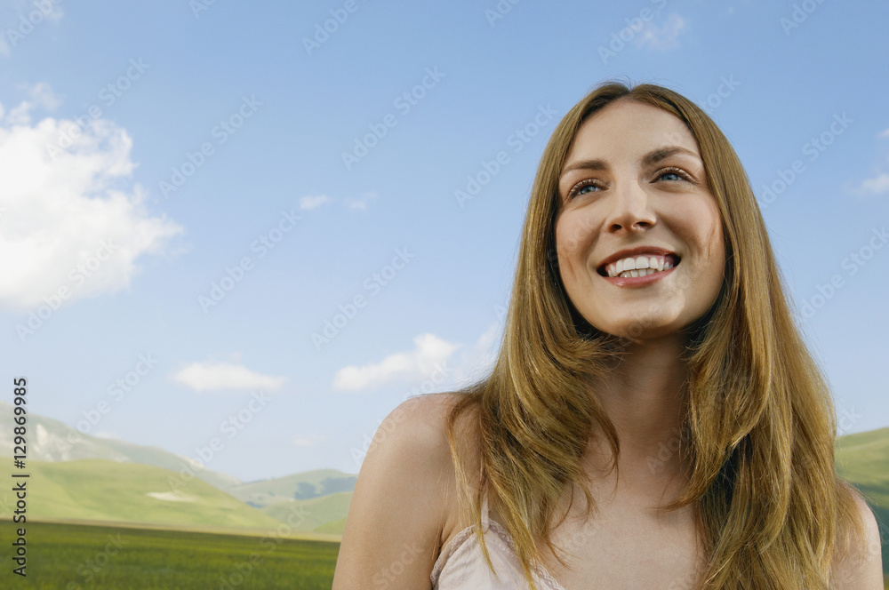 Low angle view teenage girl looking away while smiling at park