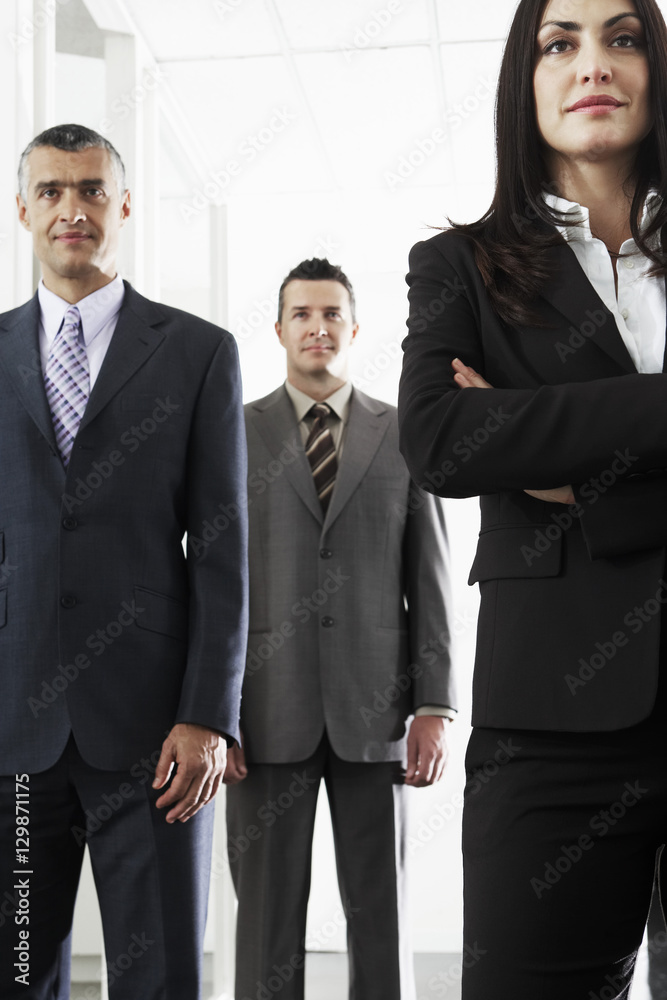 Team of confident business people standing in office Team of confident business people standing in office