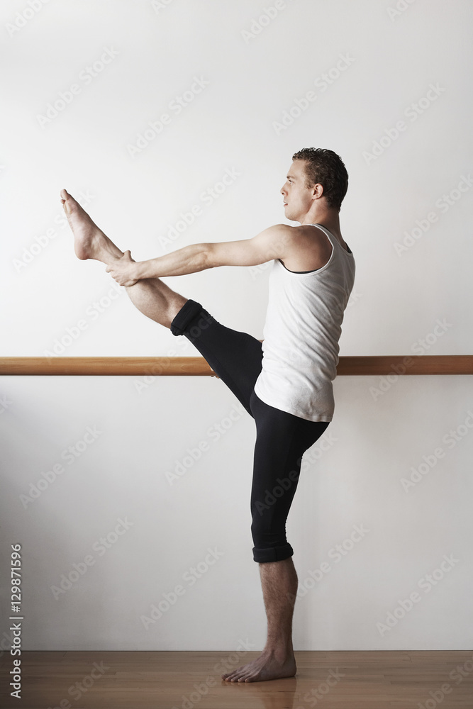 Naklejka premium Full length of male ballet dancer practicing at bar