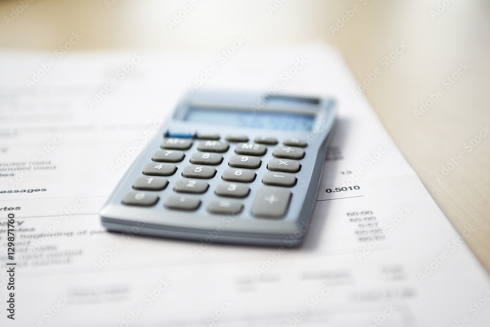 Calculator lying on telephone bill close-up Calculator lying on telephone bill close-up