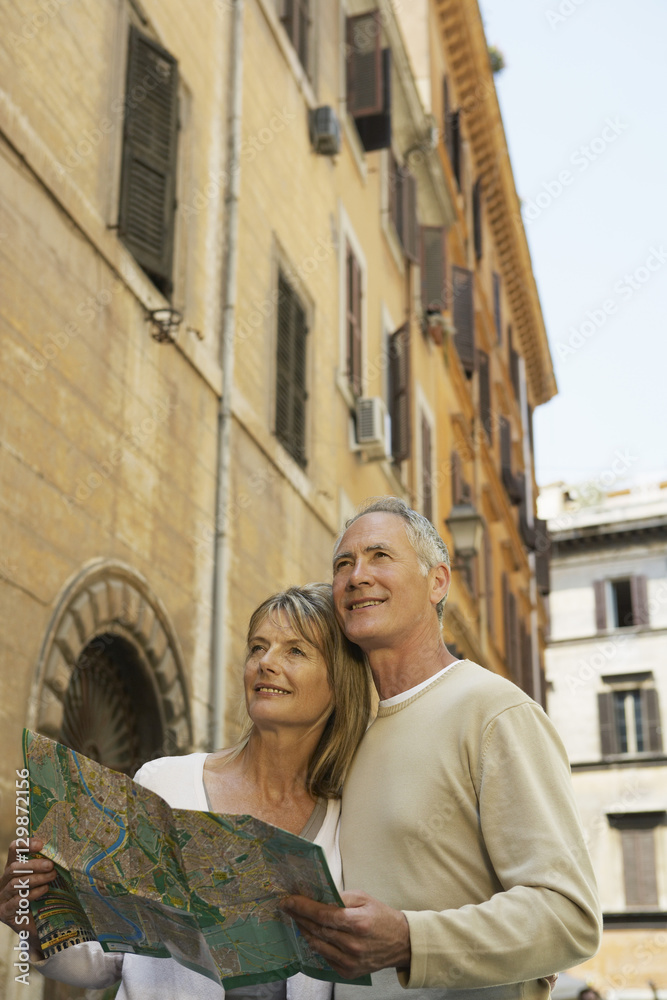 Happy couple holding map on street in Rome, Italy Happy couple holding map on street in Rome, Italy