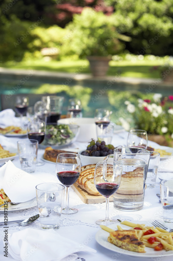 Table full of food and wine in backyard