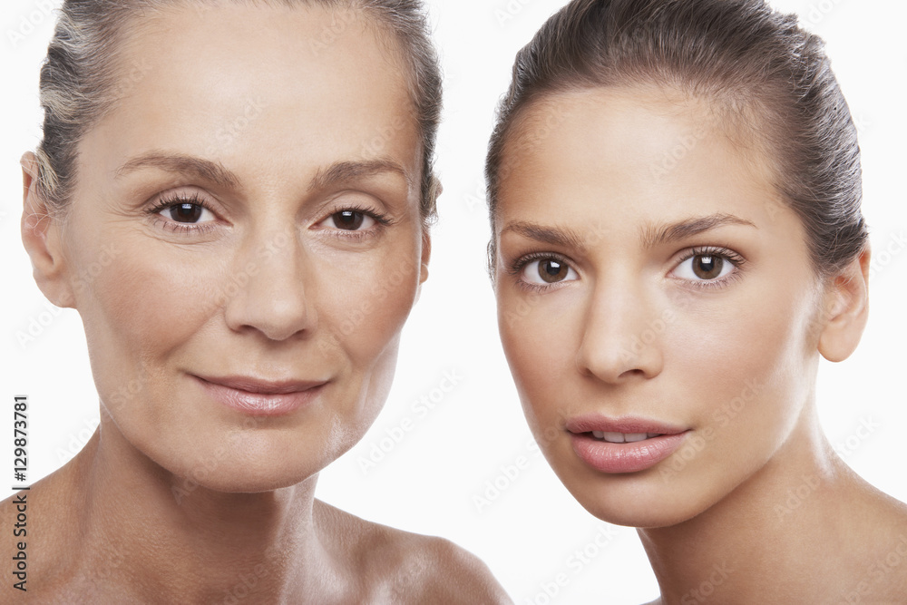 Closeup portrait of two women of different ages on white background Closeup portrait of two women of different ages on white background