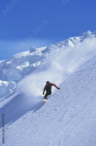 Snowboarder snowboarding on steep slope