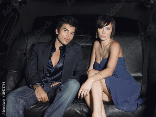 Portrait of young glamorous couple in limousine