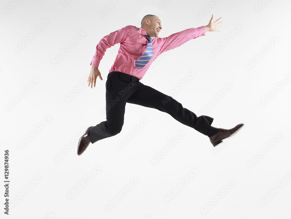 Full length of a bald businessman jumping against white background