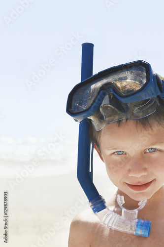 Closeup portrait of young boy wearing snorkeling goggles on beach