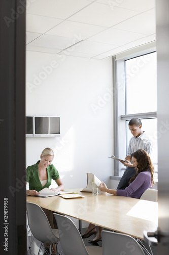 Three multiethnic office workers in conference room