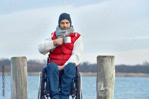 Quadro su tela Rollstuhlfahrer trinkt heißen Tee am See