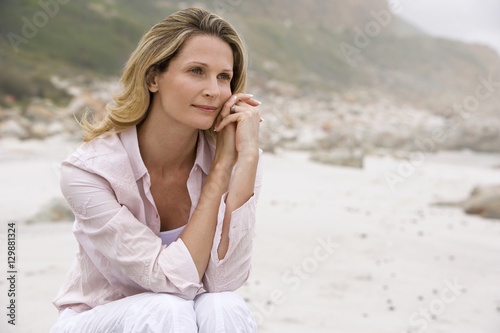 Tableau sur toile Beautiful woman daydreaming while relaxing at beach