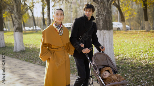 Young girl and a man walks along the avenue of the city