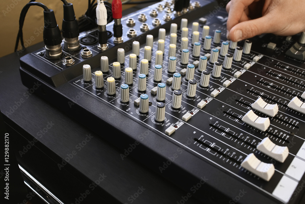 Man adjusting knob on mixing console close-up. Man adjusting knob on mixing console close-up.