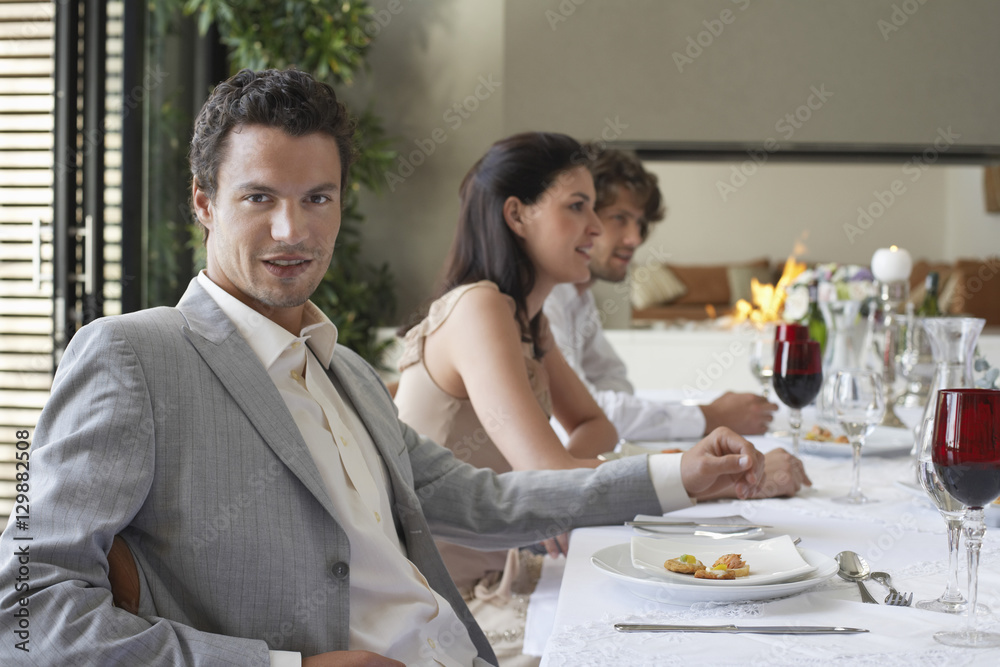 Portrait of handsome young man with friends having formal dinner party Portrait of handsome young man with friends having formal dinner party