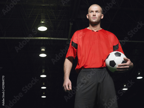 Portrait of a confident soccer player holding ball