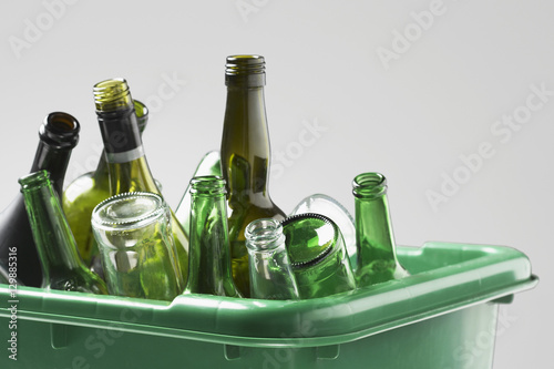 Empty bottles in green container close-up