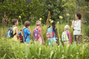 Young teacher with children on nature field trip