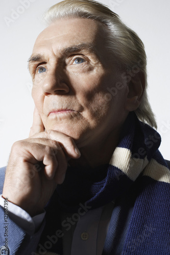 Closeup of a thoughtful senior man wearing scarf against white background
