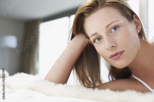 Closeup portrait of beautiful young woman relaxing in bed