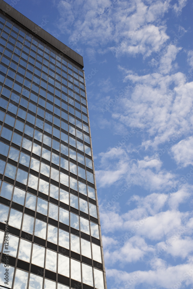 Fototapeta premium Sky and clouds reflecting in skyscraper windows low angle view
