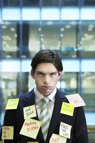 Photography Portrait of a young businessman covered with post It notes