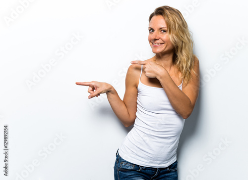 Pretty young woman pointing to the lateral