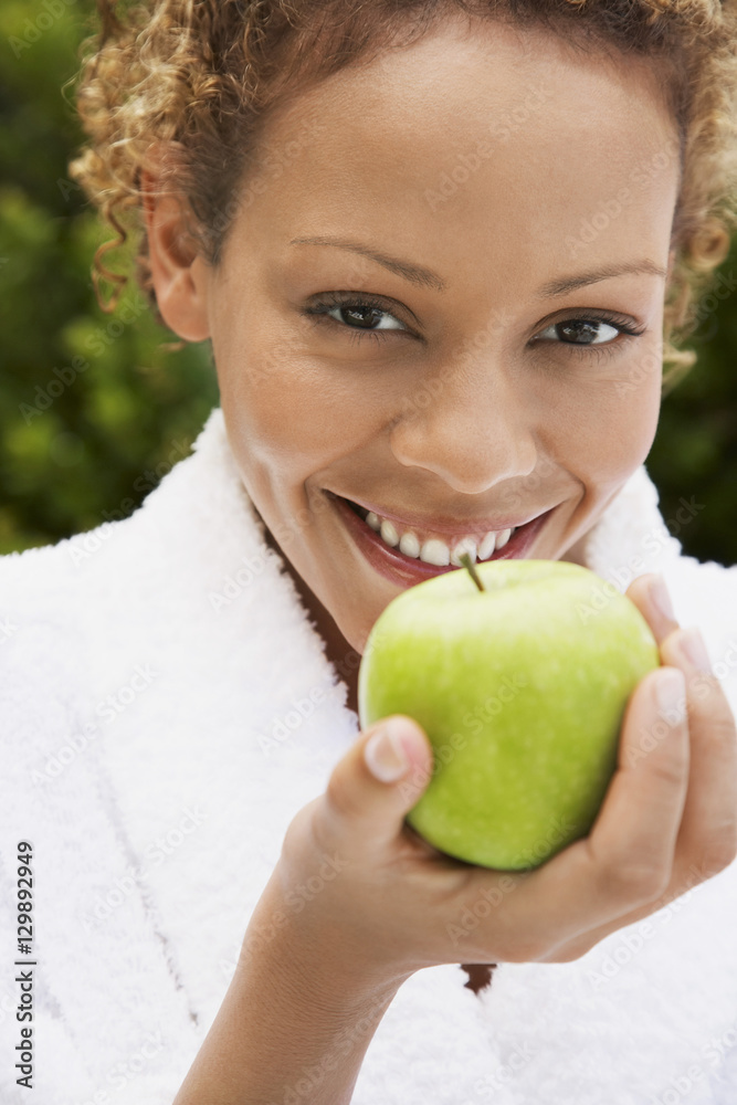 Portrait of beautiful young woman in bathrobe holding fresh green apple Portrait of beautiful young woman in bathrobe holding fresh green apple