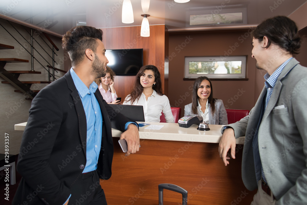 Two Business Man Arrive To Hotel Check In Woman Receptionist Registration At Reception Counter