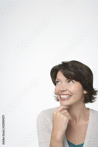 Cheerful woman looking at copyspace isolated over white background