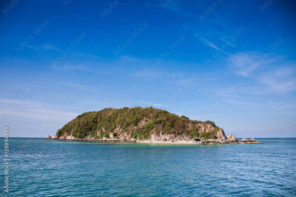 Small island in the middle of the sea and blue sky.