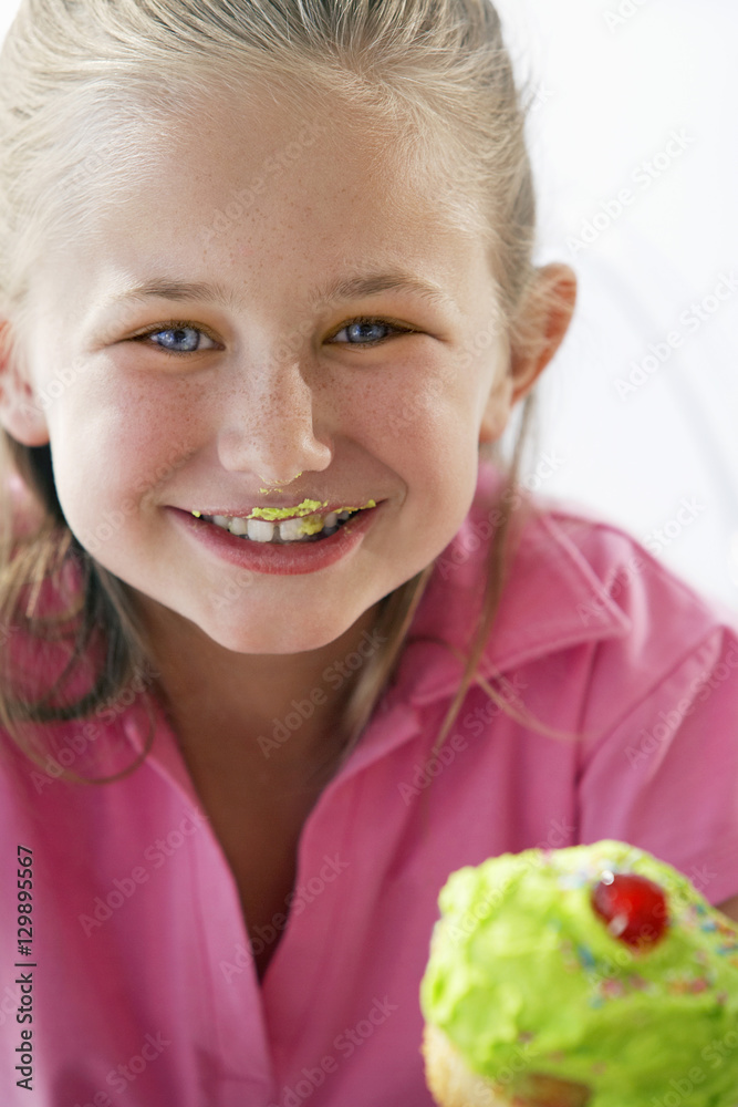 Portrait of cute young girl eating cupcake Portrait of cute young girl eating cupcake