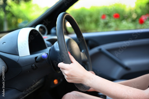 Female hands and steering wheel, closeup