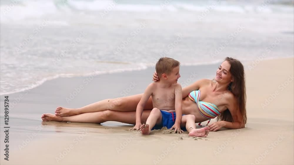Young Mother and Her Son Playing in the Sand, on the Coast Young Mother and Her Son Playing in the Sand, on the Coast
