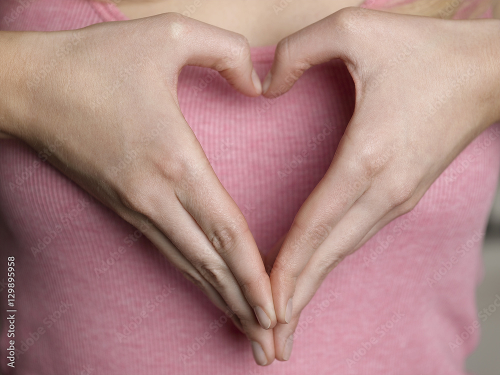 Closeup midsection of a woman making heart shape with hands Closeup midsection of a woman making heart shape with hands