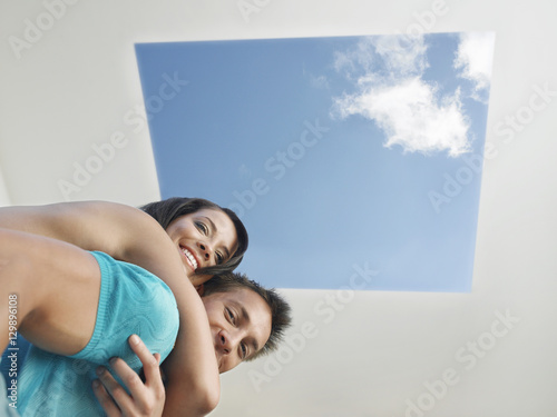 Bilde på lerret Low angle view of an affectionate young couple under skylight