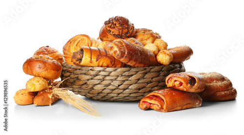 Assortment of fresh pastries in wicker bowl isolated on white photo