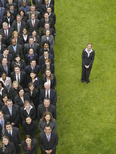 Businesswoman standing next to large group of multiethnic businesspeople in row