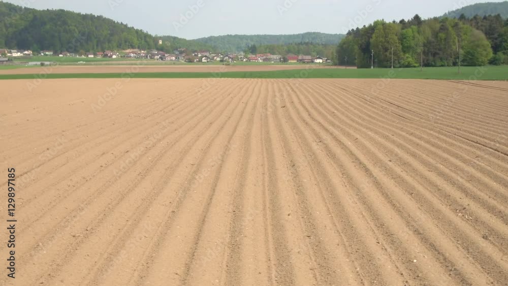 AERIAL: Empty plowed soil lines on agrarian field prepared for crop planting AERIAL: Empty plowed soil lines on agrarian field prepared for crop planting