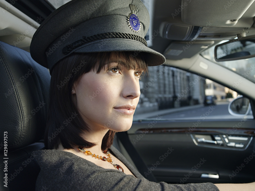 Closeup of female chauffeur in uniform driving a car Stock Photo