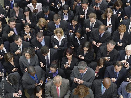 Canvas Print Elevated view of large group of business people text messaging with mobile phone